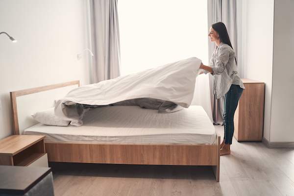 brunette woman making her bed